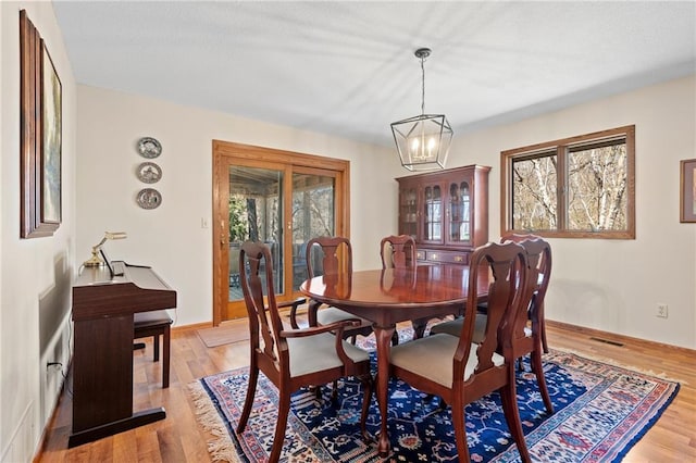 1395 25th St, Houlton, WI 54082 - dining area with light wood finished floors, a chandelier, and baseboards