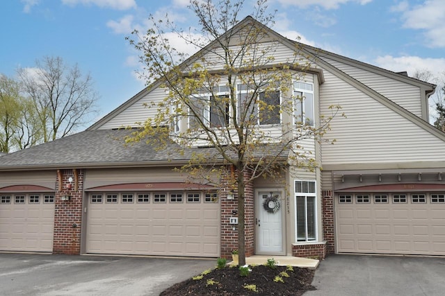 18235 W Wisconsin Ave, Brookfield, WI 53045 - view of front of home featuring brick siding, asphalt driveway, a garage, and a shingled roof