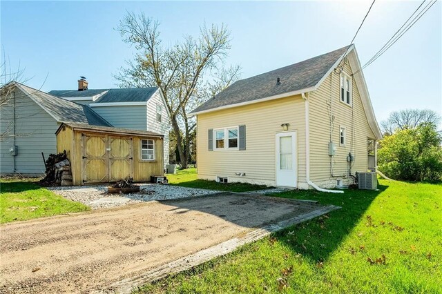 719 Huebsch Blvd, Eau Claire, WI 54701 - back of house featuring a shed, an outbuilding, a yard, and central AC