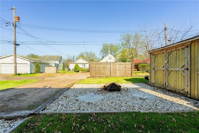 719 Huebsch Blvd, Eau Claire, WI 54701 - view of yard with a fire pit, a shed, fence, an outdoor structure, and a garage