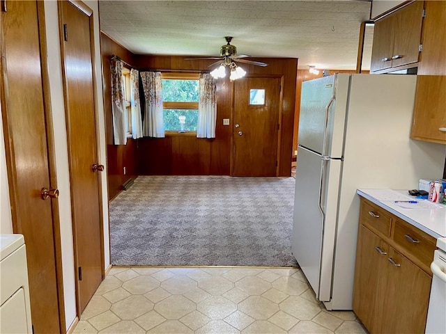 318 Spruce St, Spooner, WI 54801 - kitchen featuring light colored carpet, a ceiling fan, brown cabinets, light countertops, and wooden walls