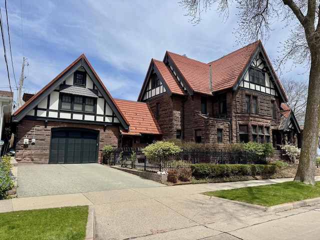 2701 N Lake Dr, Milwaukee, WI 53211 - tudor-style house with stone siding, concrete driveway, and fence