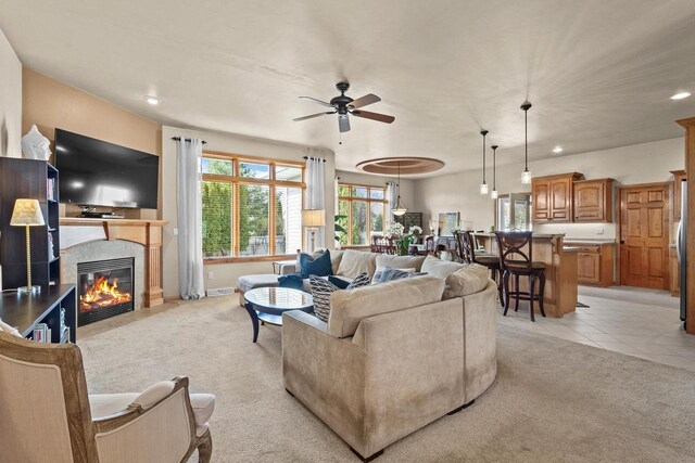 living room with ceiling fan, light colored carpet, recessed lighting, a fireplace, and baseboards