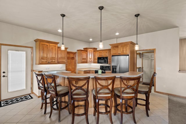 kitchen featuring black appliances, a center island, light countertops, baseboards, and light tile patterned flooring