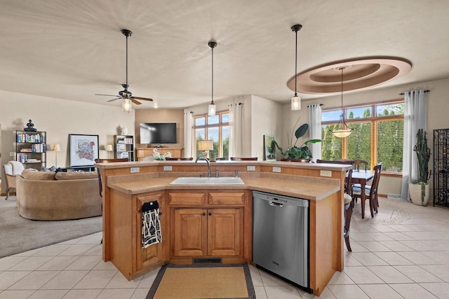 kitchen featuring stainless steel dishwasher, a sink, open floor plan, and light countertops