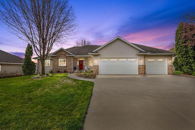 single story home with an attached garage, concrete driveway, and a lawn