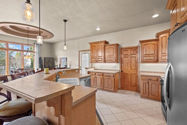 kitchen featuring appliances with stainless steel finishes, a sink, a center island with sink, a kitchen bar, and recessed lighting