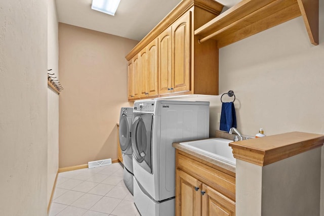 laundry area with washing machine and clothes dryer, cabinet space, light tile patterned flooring, and baseboards
