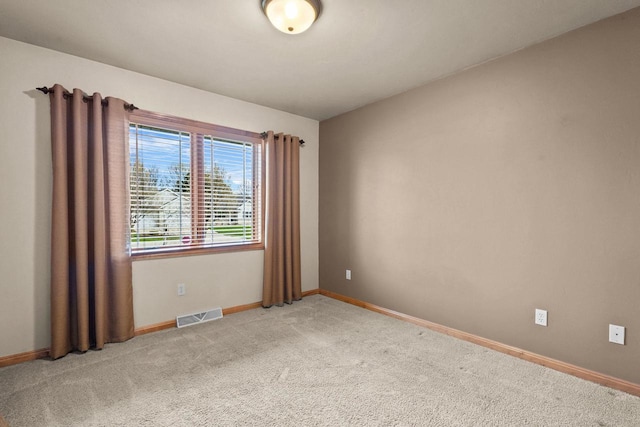unfurnished room featuring light colored carpet and baseboards