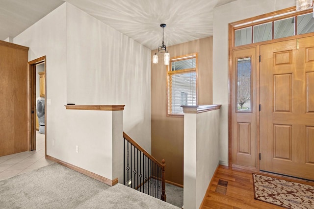 foyer entrance with baseboards and washer / dryer