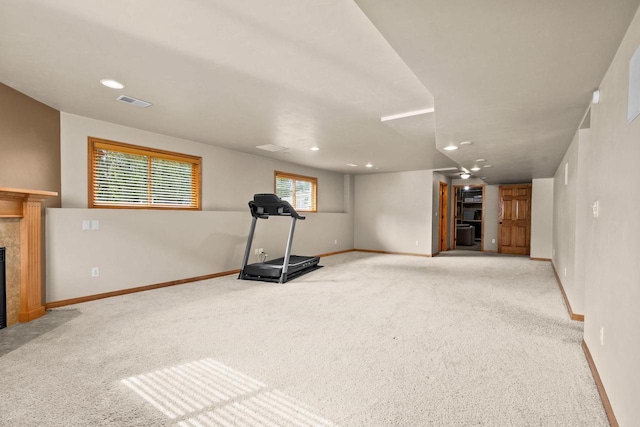 exercise room featuring a fireplace with flush hearth, carpet, baseboards, and recessed lighting