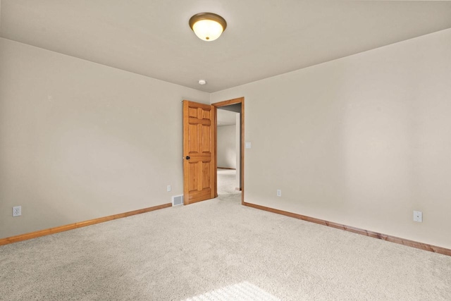 carpeted spare room featuring baseboards