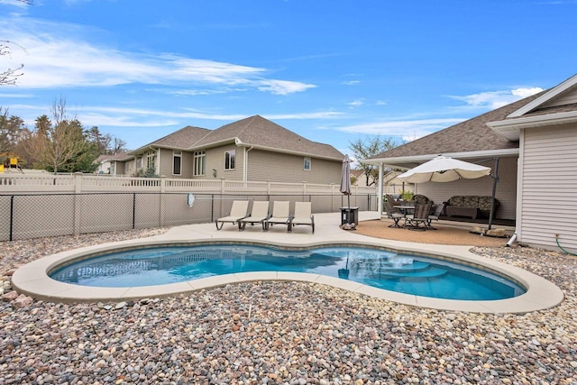 view of pool with a patio area and fence