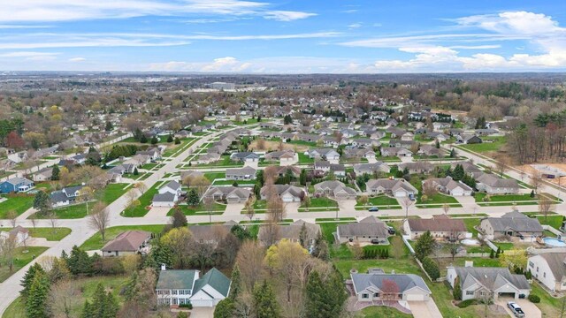 aerial view of property and surrounding area featuring nearby suburban area