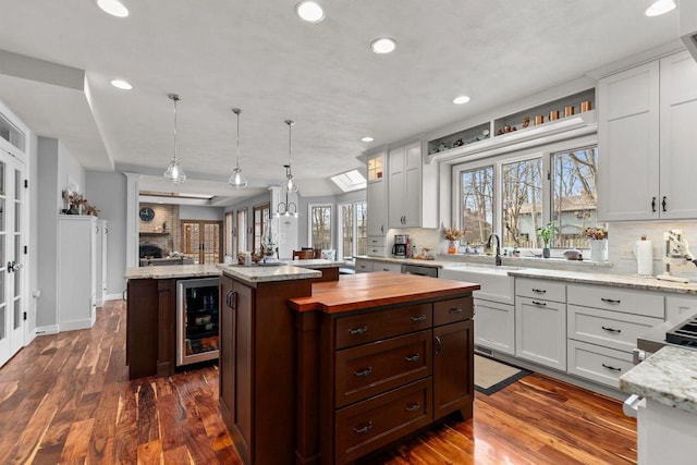3311 S Scarlet Oak Ln, Appleton, WI 54915 - kitchen featuring wine cooler, a kitchen island, a sink, tasteful backsplash, and recessed lighting