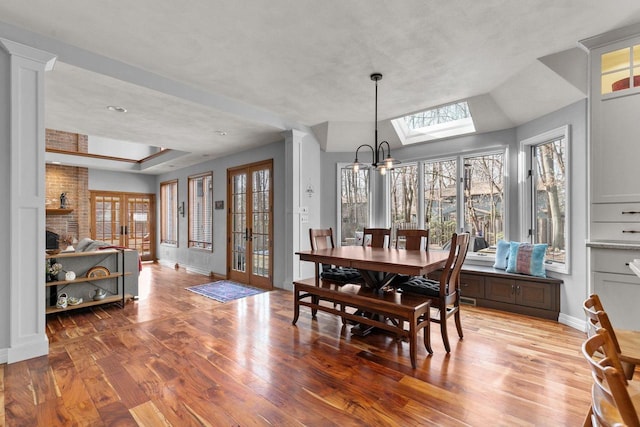 3311 S Scarlet Oak Ln, Appleton, WI 54915 - dining space with hardwood / wood-style flooring, baseboards, a chandelier, a skylight, and a raised ceiling