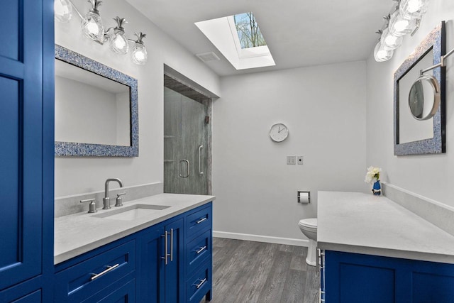 3311 S Scarlet Oak Ln, Appleton, WI 54915 - full bathroom with a skylight, wood finished floors, vanity, a shower with shower door, and baseboards