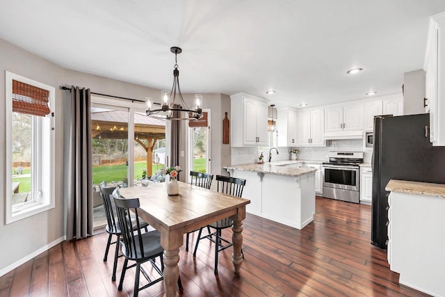 dining area with a chandelier, plenty of natural light, dark wood-style floors, baseboards, and recessed lighting