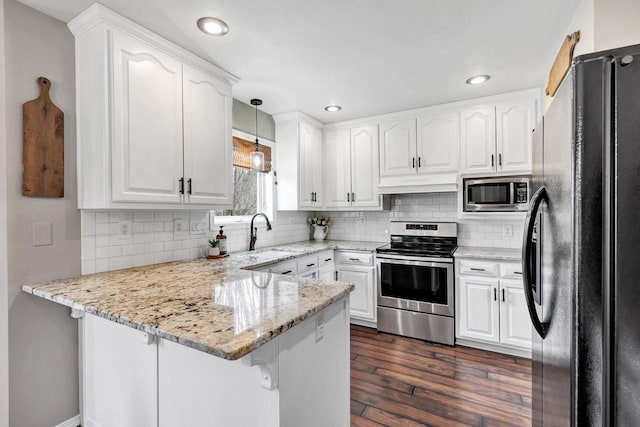 kitchen featuring appliances with stainless steel finishes, a peninsula, custom exhaust hood, white cabinets, and recessed lighting