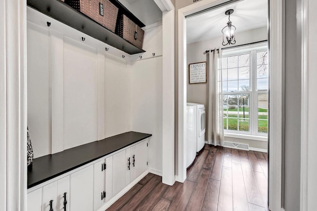 mudroom with dark wood-style flooring, washing machine and clothes dryer, and baseboards