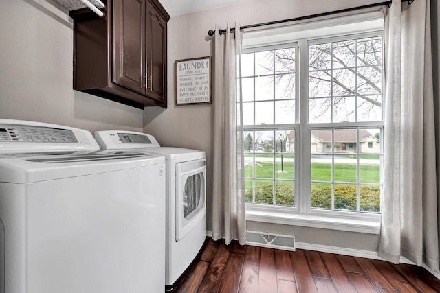 laundry room featuring cabinet space, washer and dryer, dark wood finished floors, and healthy amount of natural light