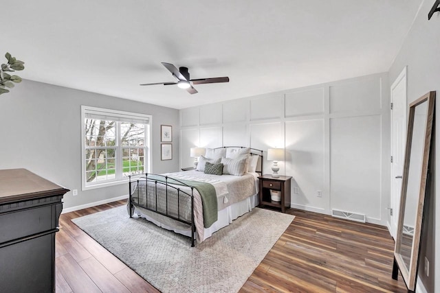 bedroom with wood finished floors, a ceiling fan, and baseboards