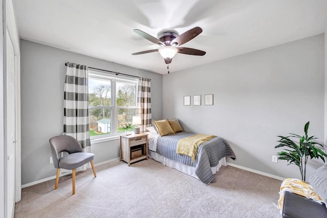 bedroom with light colored carpet, baseboards, and a ceiling fan