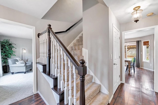 staircase featuring wood-type flooring and baseboards