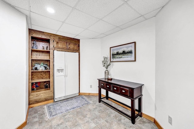 entryway with baseboards and a drop ceiling