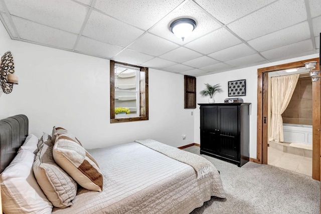 bedroom featuring carpet floors, a paneled ceiling, baseboards, and ensuite bath