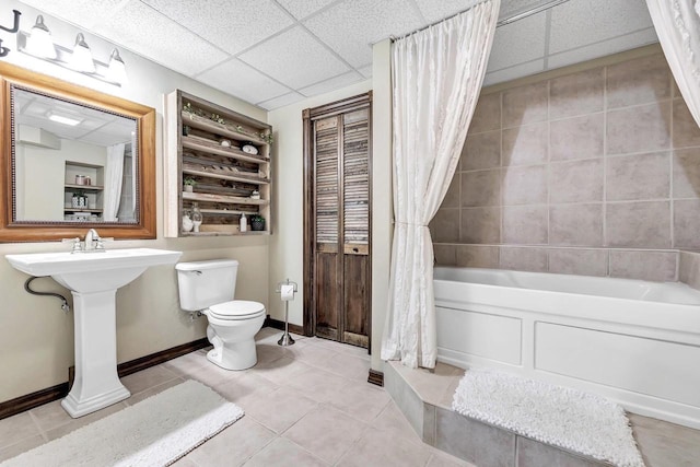 full bath featuring toilet, tile patterned flooring, a drop ceiling, and shower / bath combination with curtain