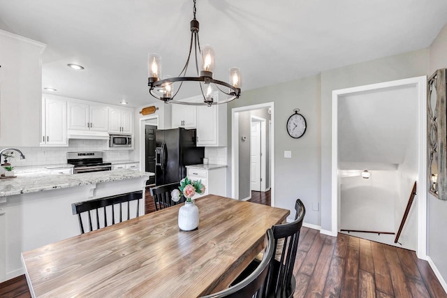 dining space featuring a chandelier, dark wood-style floors, baseboards, and recessed lighting