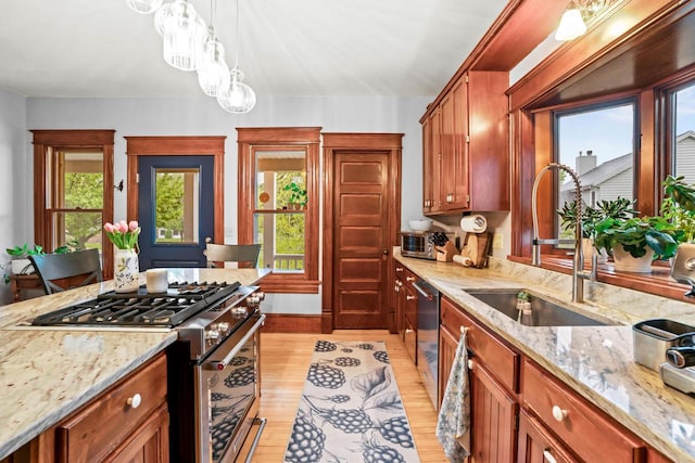 1753 Oneida Ct, Grafton, WI 53024 - kitchen with appliances with stainless steel finishes, a sink, light wood-type flooring, hanging light fixtures, and light stone countertops