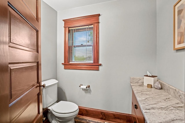 1753 Oneida Ct, Grafton, WI 53024 - half bathroom featuring toilet, vanity, and baseboards