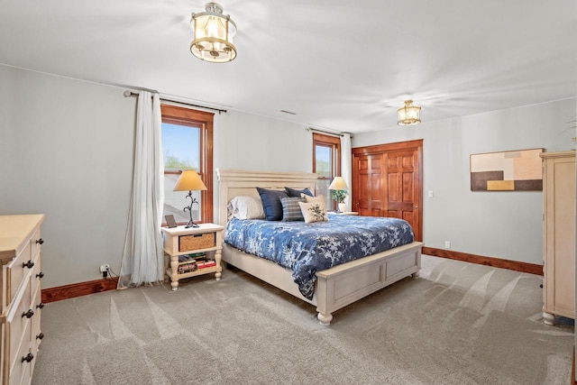 1753 Oneida Ct, Grafton, WI 53024 - bedroom featuring a chandelier, baseboards, and light colored carpet