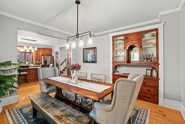 1753 Oneida Ct, Grafton, WI 53024 - dining space with ornamental molding, light wood-style floors, stairway, and a chandelier