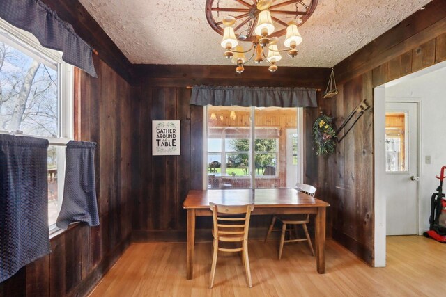 4121 1st Ave, Briggsville, WI 53920 - dining room with a chandelier, wood walls, wood finished floors, and a textured ceiling
