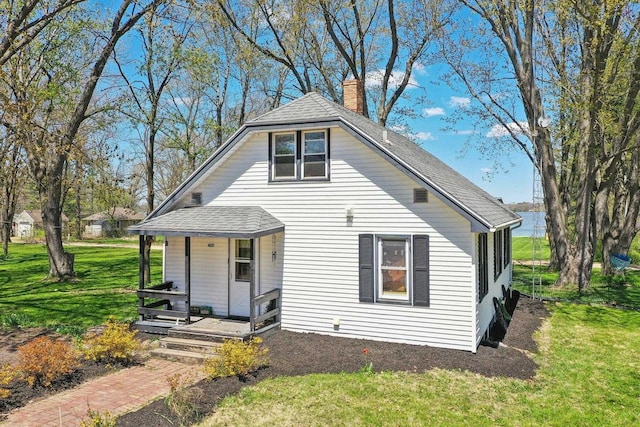 4121 1st Ave, Briggsville, WI 53920 - bungalow-style house featuring covered porch, a chimney, a front yard, and roof with shingles