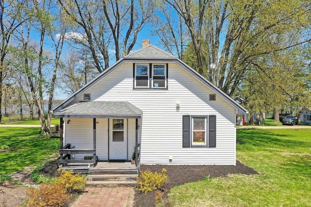4121 1st Ave, Briggsville, WI 53920 - bungalow with covered porch, a chimney, a front yard, and roof with shingles
