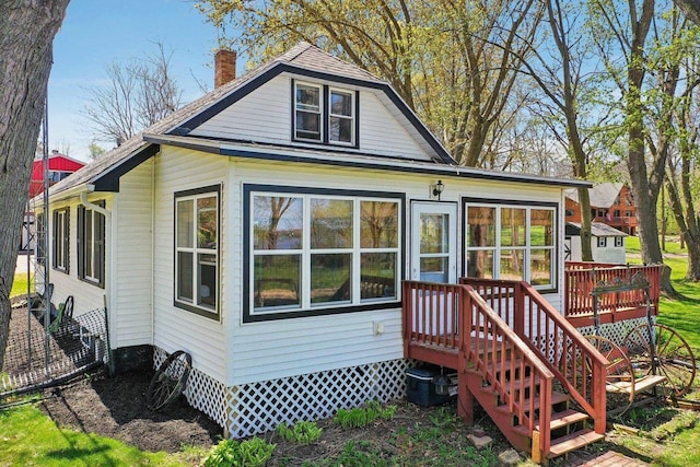 4121 1st Ave, Briggsville, WI 53920 - back of house featuring a chimney, central AC, and a sunroom