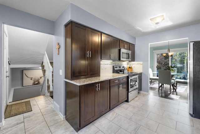 5719 Highland Way, Middleton, WI 53562 - kitchen featuring appliances with stainless steel finishes, dark brown cabinetry, decorative backsplash, light stone countertops, and decorative light fixtures