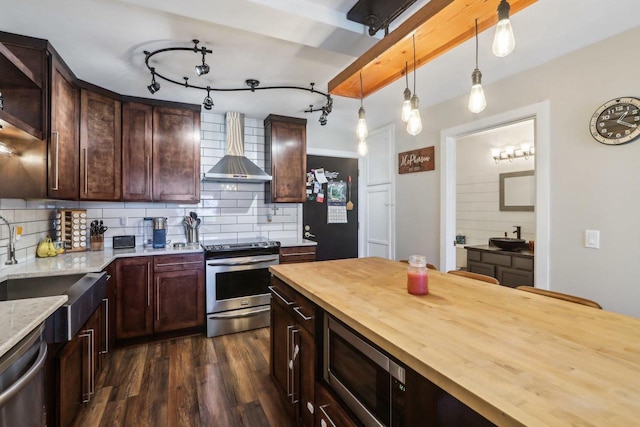 6941 Chester Dr Unit C, Madison, WI 53719 - kitchen featuring butcher block countertops, appliances with stainless steel finishes, wall chimney exhaust hood, backsplash, and dark wood-type flooring