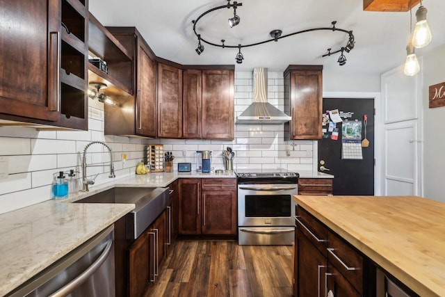 6941 Chester Dr Unit C, Madison, WI 53719 - kitchen featuring appliances with stainless steel finishes, wall chimney exhaust hood, butcher block counters, dark wood-style flooring, and tasteful backsplash