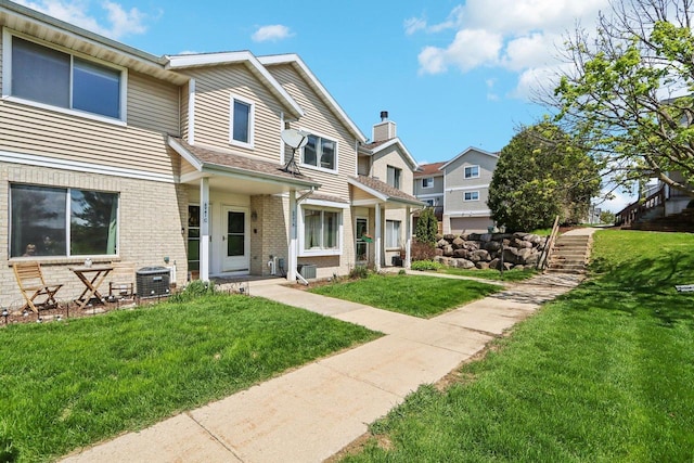 6941 Chester Dr Unit C, Madison, WI 53719 - view of property featuring brick siding, a front lawn, a residential view, and central air condition unit