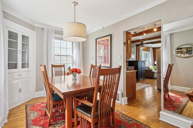 dining room featuring a ceiling fan, light wood-style flooring, ornamental molding, and baseboards