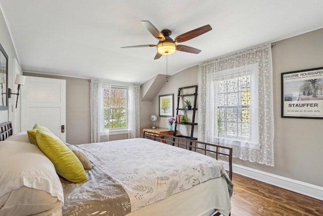 bedroom with wood finished floors, baseboards, a ceiling fan, and lofted ceiling