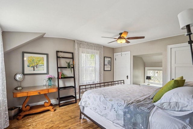 bedroom featuring multiple windows, wood finished floors, and ceiling fan