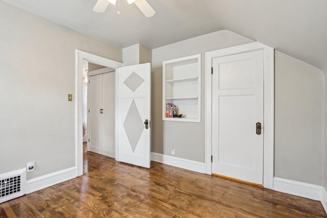 unfurnished bedroom featuring wood finished floors, lofted ceiling, baseboards, and ceiling fan