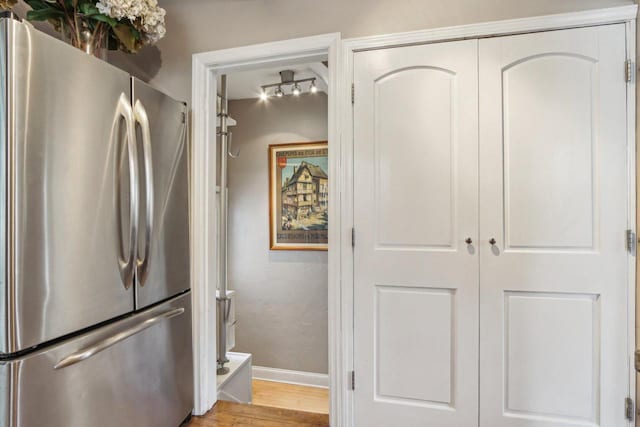 kitchen featuring freestanding refrigerator, baseboards, and light wood-style floors