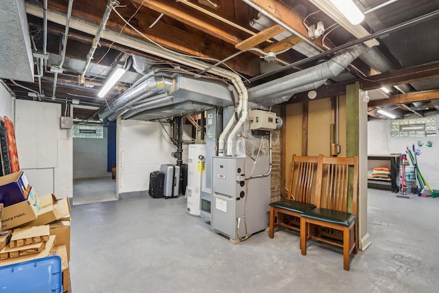 below grade area with electric water heater, heating unit, and a water softener system